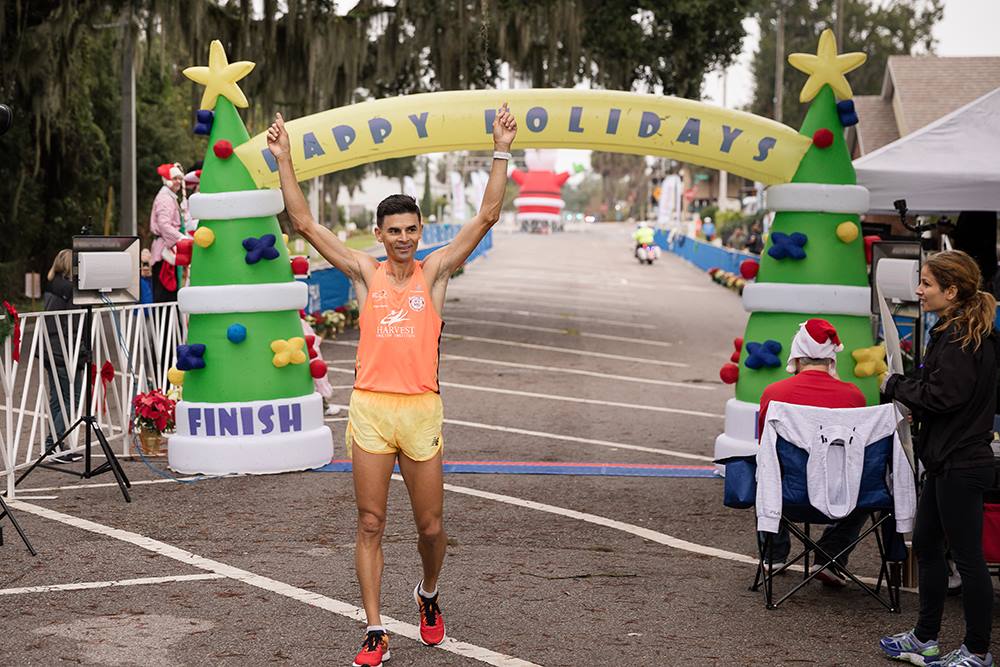 man crossing Mount Dora 5K finish line